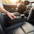 Person sliding the car seat gap filler into the seat gap so items stop falling through