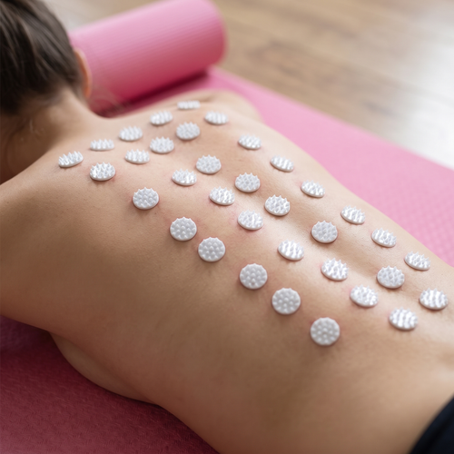 Close-up of acupressure mat spikes against a relaxed back