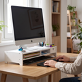 Person at tidy desk with monitor raised on a stand riser at eye level